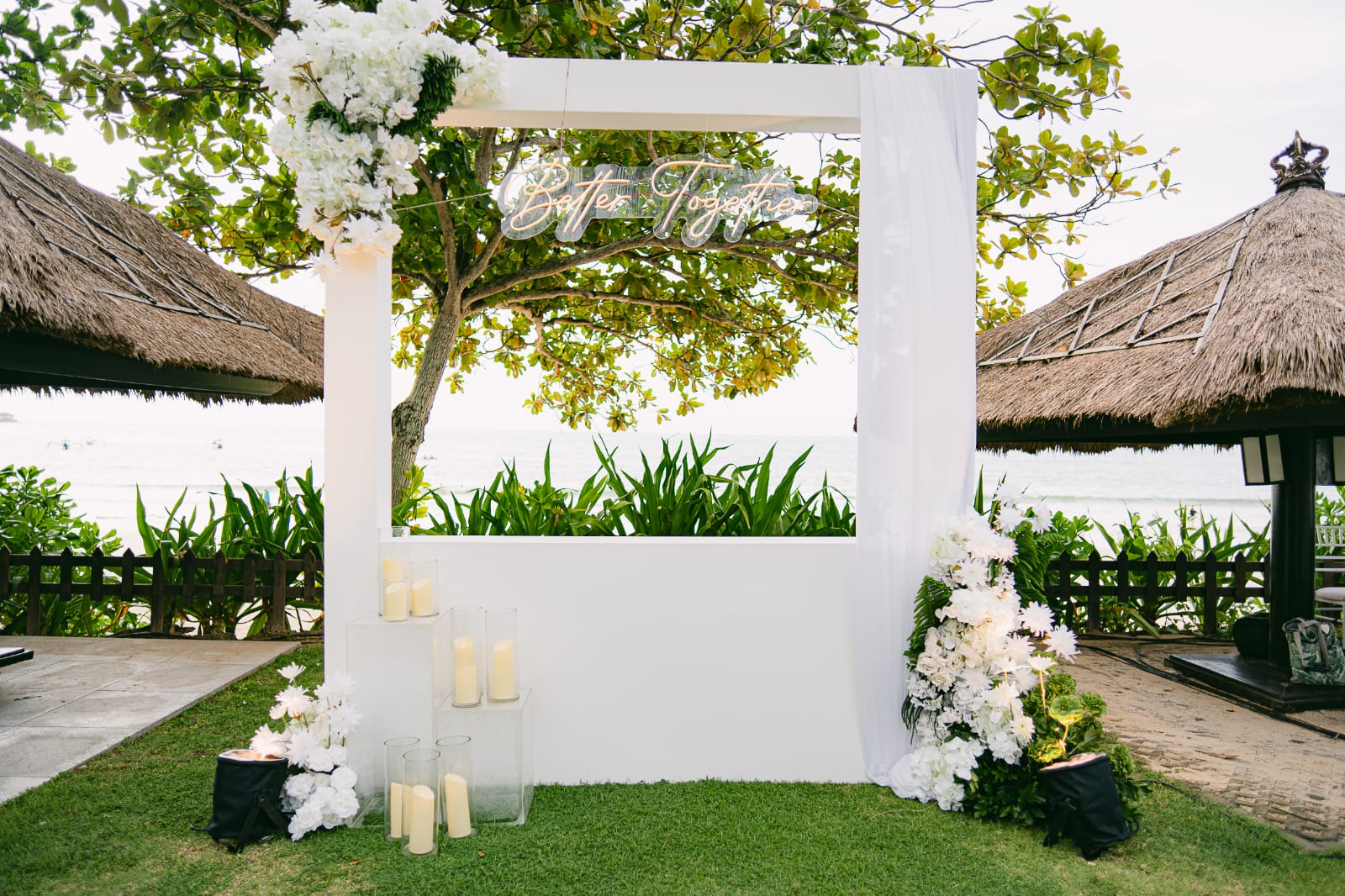 white ceremony arch with floral base accents