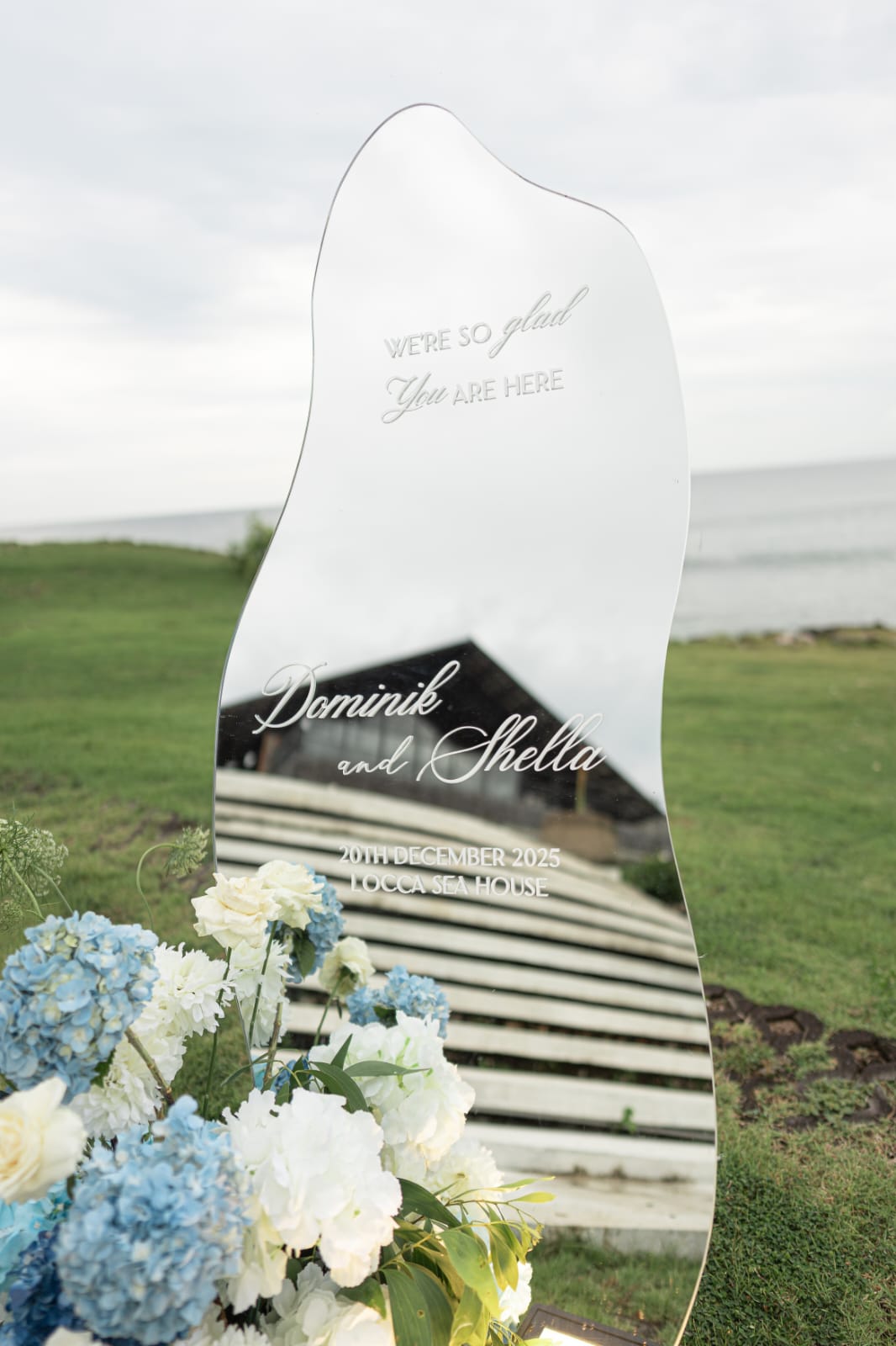 oceanfront wedding welcome sign with blue and white floral base