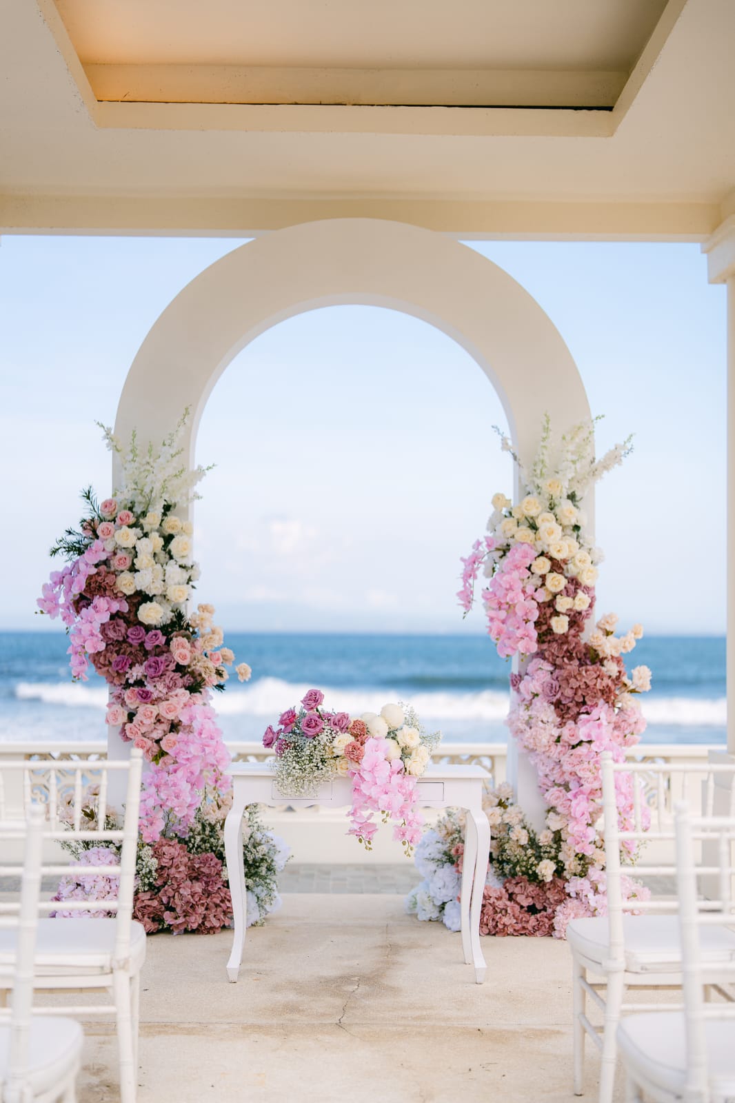pink floral ceremony arch overlooking the ocean